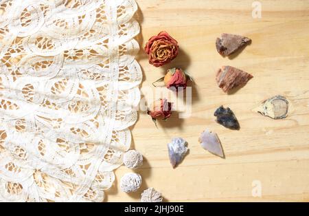 Vintage Lace mit Perlen und indianischen Pfeilspitzen auf Holzhintergrund Stockfoto