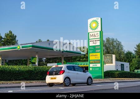 BP-Tankstelle zeigt ein hohes britisches Kraftstoffpreisschild und ein Fahrzeug in Bewegung Stockfoto