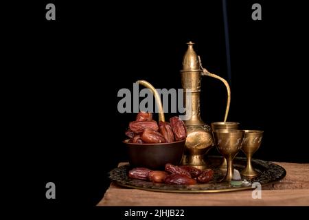 Tee und getrocknete Datteln auf einem alten Holztisch. Stockfoto