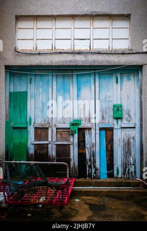 Straßenszene mit einem Handwagen vor einem geschlossenen Laden in Tai O, Lantau Island, Hongkong, 2009 Stockfoto