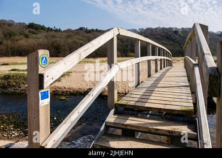 Schild des Wales Coast Path auf der Fußgängerbrücke über den Nicholaston pill Stream im Oxwich National Nature Reserve auf der Gower Peninsula, West Glamorgan, South Wales, Großbritannien Stockfoto