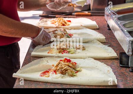 Hände eines professionellen Küchenchefs, der Shawarma in einem arabischen Restaurant zubereitet Stockfoto