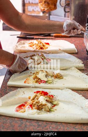 Hände eines professionellen Küchenchefs, der Shawarma in einem arabischen Restaurant zubereitet Stockfoto