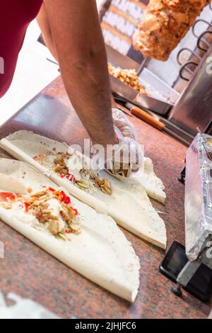 Hände eines professionellen Küchenchefs, der Shawarma in einem arabischen Restaurant zubereitet Stockfoto