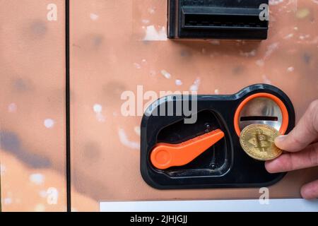 Frau oder weibliche Hand, die goldene Bitcoin in den Verkaufsautomaten, um Brot oder Lebensmittel, digitales Finanzkonzept zu kaufen. Hochwertige Fotos Stockfoto