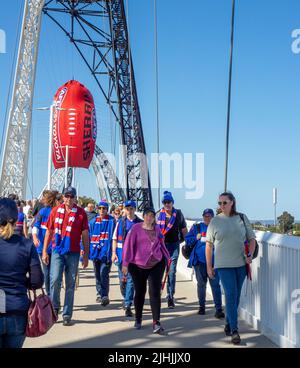 Zuschauer, die mit einem aufblasbaren Fußball über die Matagarup Bridge zum AFL Grand Final 2021 im Otpus Stadium Perth Western Australia laufen. Stockfoto