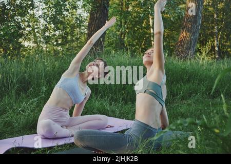 Zwei junge Frauen machen Yoga im Freien, psychische Gesundheit Stockfoto