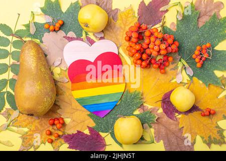 Drei Herzen in LGBT-Farben gemalt, rot und Holz als Symbol der Liebe, gegenseitiges Verständnis, Frieden und Frucht auf einem hellen bunten Hintergrund Stockfoto