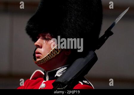 Ein Mitglied der Scots Guards der F Company schwelgt während der Wachwechsel-Zeremonie auf dem Vorplatz des Buckingham Palace im Zentrum von London in der Hitze. Die Briten werden am heißesten britischen Tag der Rekorde schmelzen, da die Temperaturen voraussichtlich auf 40C steigen werden. Bilddatum: Dienstag, 19. Juli 2022. Stockfoto