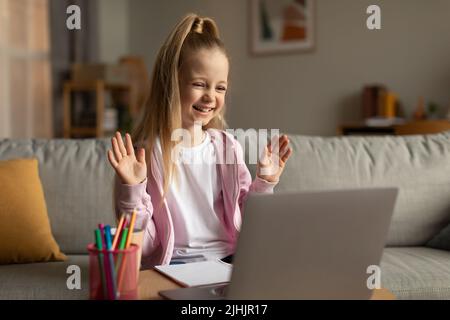 Schulmädchen Machen Video-Anruf Winken Hallo Zu Laptop Zu Hause Stockfoto