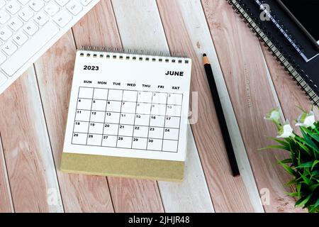 Weißer Kalender Juni 2023 auf Holztisch. Flach liegend. Stockfoto