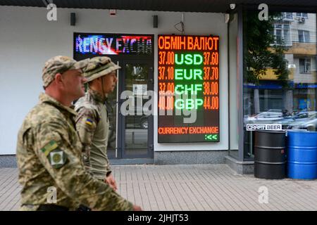 Kiew, Ukraine. 18.. Juli 2022. Soldaten gehen an ein Schild, das den Wechselkurs der ukrainischen Griwna gegen eine Fremdwährung in Kiew anzeigt. Der US-Dollar ist in der vergangenen Woche stark gestiegen, aber mehr als vier Monate nach der russischen Invasion in die Ukraine kämpfen Politiker in Kiew darum, den Haushalt am Laufen zu halten, während das Militär des Landes gegen die russische Invasion kämpft. Kredit: SOPA Images Limited/Alamy Live Nachrichten Stockfoto