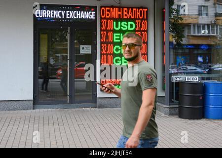 Kiew, Ukraine. 18.. Juli 2022. Ein Mann geht in der Nähe eines Schildes, das den Wechselkurs der ukrainischen Griwna gegen die Fremdwährung in Kiew anzeigt. Der US-Dollar ist in der vergangenen Woche stark gestiegen, aber mehr als vier Monate nach der russischen Invasion in die Ukraine kämpfen Politiker in Kiew darum, den Haushalt am Laufen zu halten, während das Militär des Landes gegen die russische Invasion kämpft. Kredit: SOPA Images Limited/Alamy Live Nachrichten Stockfoto