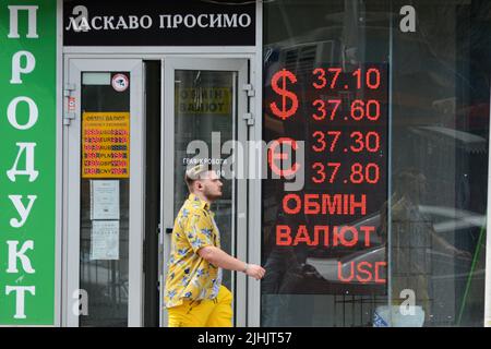 Kiew, Ukraine. 18.. Juli 2022. Ein Mann geht in der Nähe eines Schildes, das den Wechselkurs der ukrainischen Griwna gegen die Fremdwährung in Kiew anzeigt. Der US-Dollar ist in der vergangenen Woche stark gestiegen, aber mehr als vier Monate nach der russischen Invasion in die Ukraine kämpfen Politiker in Kiew darum, den Haushalt am Laufen zu halten, während das Militär des Landes gegen die russische Invasion kämpft. Kredit: SOPA Images Limited/Alamy Live Nachrichten Stockfoto