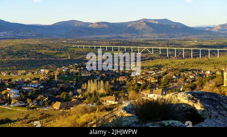 Sonnenuntergang in den Bergen mit kleinen Dörfern am Berghang, Kühe und Bauernhöfe auf dem Land. Navacerrada Madrid. Spanien. Stockfoto