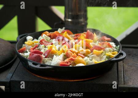 Ein Eintopf aus Paprika, Kartoffeln, Rindfleisch, Kohl und anderem Gemüse in einem gusseisernen Kessel Stockfoto