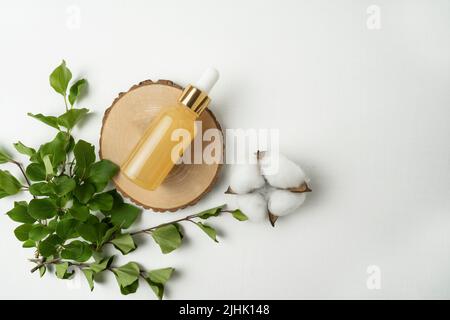 Natürliches Anti-Aging-Gesichtsserum mit Vitamin C oder ätherischem Öl auf einem Holzteller Stockfoto