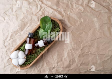 Zwei Flaschen mit leeren Etiketten für jede Marke, die auf einem grünen Moos liegen Stockfoto