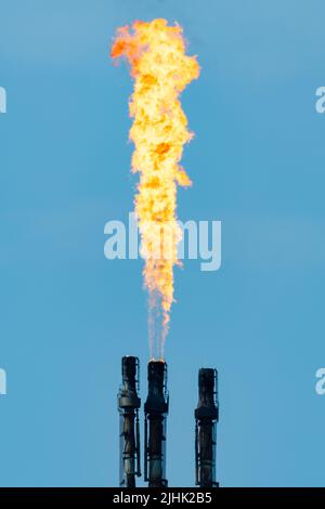 Gasflackern in der Ölraffinerie, Fackelstapel, der überschüssiges Gas abbrennt. Ölraffinerie Flamme, Fackeln, Abfackeln, Schornstein, Verschmutzung, Petrochemie, Rauchschornstein. VEREINIGTES KÖNIGREICH Stockfoto