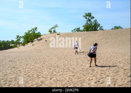 Mutter und Sohn wandern die steilen Dünen am Sandbanks Dunes Beach, Prince Edward County, Ontario, Kanada. Stockfoto