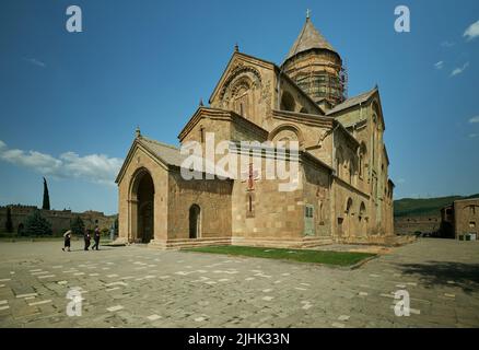 Kathedrale von Svetizchoveli (Kathedrale der Lebendigen Säule) in Mzcheta, Georgien, Außenansicht von Tageslicht mit Besuchern, die die Kathedrale betreten Stockfoto