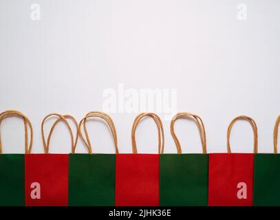 Eine Reihe von bunten Papier-Einkaufstaschen auf weißem Hintergrund Stockfoto