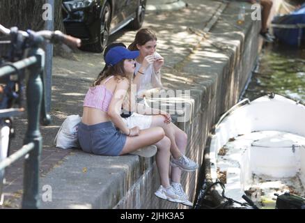 Amsterdam, Niederlande. 19.. Juli 2022. Junge Touristen machen am 19. Juli 2022 in Amsterdam, Niederlande, eine Pause für einen Snack an der Prinsengracht. In einigen Regionen der Niederlande wurden Temperaturen von 39 Grad Celsius prognostiziert, das niederländische Wetterbüro (KNMI) gab eine Code-Orange-Wetterwarnung heraus. (Foto von Paulo Amorim/Sipa USA) Quelle: SIPA USA/Alamy Live News Stockfoto