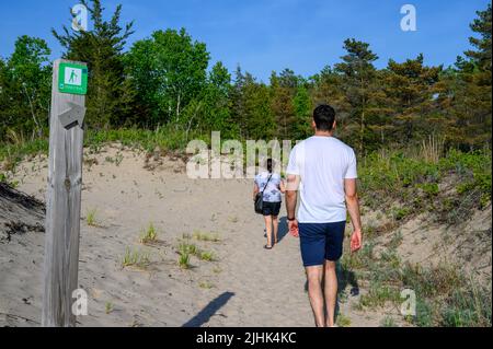 Mutter und Sohn indischer Abstammung und gemischter Rennen wandern entlang des Dunes Trail am Sandbanks Dunes Beach, Prince Edward County, Ontario, Kanada. Stockfoto