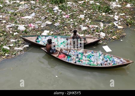 Dhaka, Bangladesch - 15. Juli 2022: Täglich werden Hunderte von Plastikflaschen vom Start an in den Buriganga River in Dhaka geworfen. Zwei Teenager Stockfoto