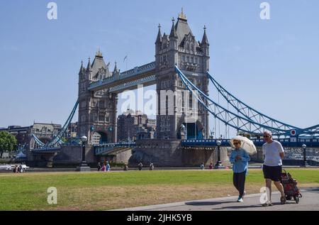 London, Großbritannien. 19.. Juli 2022. Eine Frau, die sich mit einem Sonnenschirm vor der Sonne schützt, geht an der Tower Bridge vorbei, während Großbritannien seine höchsten Temperaturen verzeichnet. Kredit: Vuk Valcic/Alamy Live Nachrichten Stockfoto