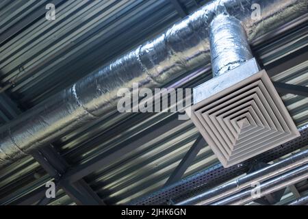 Versorgungsgitter für die industrielle Lüftung in einem Bürogebäude unter der Decke, hlk-Technik Kommunikation Stockfoto