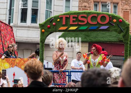 Männer, die als Frauen gekleidet waren, in einem Straßenzug bei London Pride, unterstützt von Tesco, London, England, Großbritannien 2022 Stockfoto