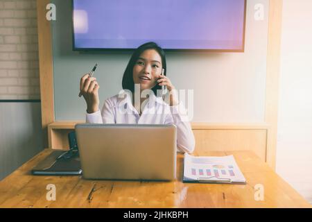 Geschäftsfrau telefoniert und lächelt. Sekretärin antwortet auf ihr Handy. Stockfoto