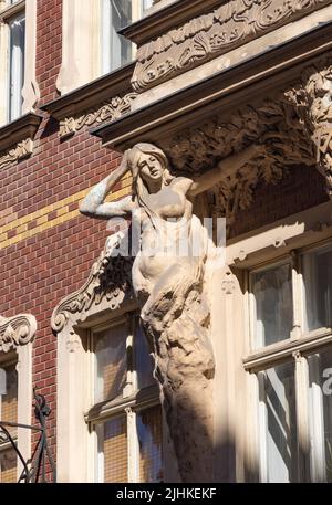 Riga Lettland; Jugendstilarchitektur - Statue einer Frau auf einem Gebäude in der Altstadt von Riga, Rigaer Statuen, Lettland Europa Stockfoto