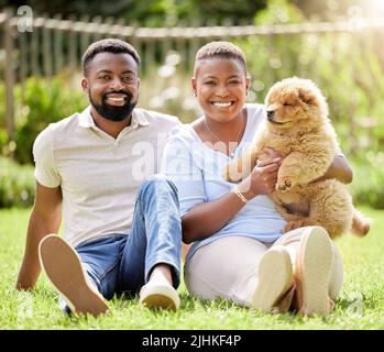 Wir alle lieben es, im Park zu hängen. Porträt eines jungen Paares, das sich mit seinem Hund im Freien entspannt. Stockfoto