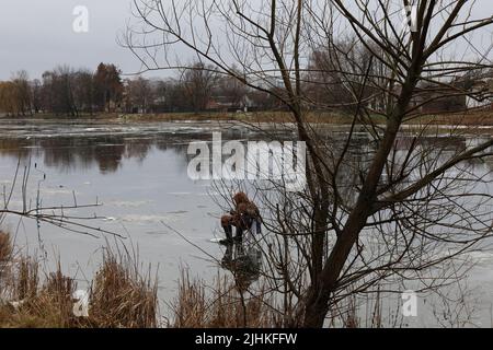 Fischer stehen auf dem Fluss, Frühling, schmilzt Eis Stockfoto