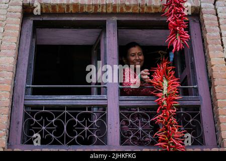 Lalitpur, Nepal. 19.. Juli 2022. Am 19. Juli 2022 in Lalitpur, Nepal. Frauen bereiten sich darauf vor, rote Chilis in ihrem Haus zu trocknen, nachdem sie sie im alten Tal von Khokhana gewebt haben. (Foto: Abhishek Maharjan/Sipa USA) Quelle: SIPA USA/Alamy Live News Stockfoto