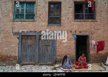 Lalitpur, Nepal. 19.. Juli 2022. Am 19. Juli 2022 in Lalitpur, Nepal. Frauen mit ihrem Nachbarn im alten Tal von Khokhana webt rote Chilis in ihrem Haus, um sie zu trocknen. (Foto: Abhishek Maharjan/Sipa USA) Quelle: SIPA USA/Alamy Live News Stockfoto