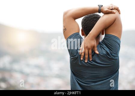 Rückansicht eines jungen afroamerikanischen Athleten, der beim Stretching vor dem Training im Freien einen Blick auf den Blick hat. Engagierter schwarzer Mann Stockfoto