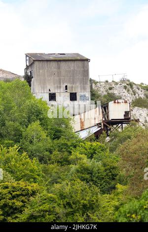 Asbest verkleideter shoreham-Zement arbeitet jetzt verfällt mit Stütztürmen und Förderern gebrochene Fenster und Asbestplatten ein braunes Feld-Gelände eingezäunt Stockfoto