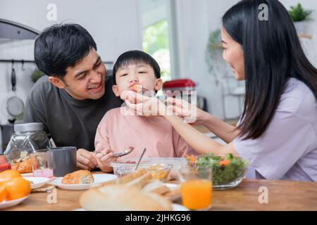 Glückliche asiatische Familie, Junge essen gesunde Lebensmittel zusammen Stockfoto