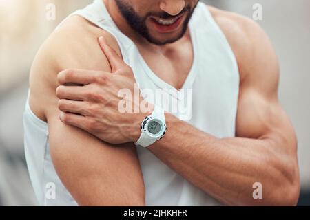 Ein unbekannter gemischter Tennisspieler mit Schulterverletzung im Gerichtsspiel. Hispanic fit professionell in Schmerzen beim Halten und Reiben Arm Stockfoto