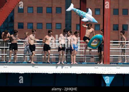 Manchester, Großbritannien, 19.. Juli 2022. Die Öffentlichkeit wird am Salford Quays in Manchester im Wasser gesehen, als am Sonntag um Mitternacht die erste rote Warnung Großbritanniens vor außergewöhnlicher Hitze in Kraft trat. Die Temperaturen in einigen Teilen des Landes sind auf über 40 Grad Celsius angestiegen und brechen damit die Hitzeberichte des Landes, Manchester, Großbritannien. Kredit: Jon Super/Alamy Live Nachrichten. Stockfoto