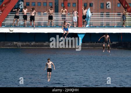 Manchester, Großbritannien, 19.. Juli 2022. Die Öffentlichkeit wird am Salford Quays in Manchester im Wasser gesehen, als am Sonntag um Mitternacht die erste rote Warnung Großbritanniens vor außergewöhnlicher Hitze in Kraft trat. Die Temperaturen in einigen Teilen des Landes sind auf über 40 Grad Celsius angestiegen und brechen damit die Hitzeberichte des Landes, Manchester, Großbritannien. Kredit: Jon Super/Alamy Live Nachrichten. Stockfoto