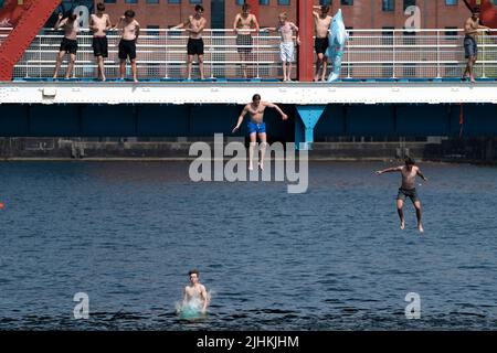 Manchester, Großbritannien, 19.. Juli 2022. Die Öffentlichkeit wird am Salford Quays in Manchester im Wasser gesehen, als am Sonntag um Mitternacht die erste rote Warnung Großbritanniens vor außergewöhnlicher Hitze in Kraft trat. Die Temperaturen in einigen Teilen des Landes sind auf über 40 Grad Celsius angestiegen und brechen damit die Hitzeberichte des Landes, Manchester, Großbritannien. Kredit: Jon Super/Alamy Live Nachrichten. Stockfoto