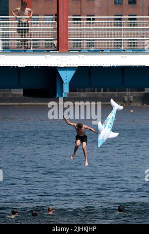 Manchester, Großbritannien, 19.. Juli 2022. Die Öffentlichkeit wird am Salford Quays in Manchester im Wasser gesehen, als am Sonntag um Mitternacht die erste rote Warnung Großbritanniens vor außergewöhnlicher Hitze in Kraft trat. Die Temperaturen in einigen Teilen des Landes sind auf über 40 Grad Celsius angestiegen und brechen damit die Hitzeberichte des Landes, Manchester, Großbritannien. Kredit: Jon Super/Alamy Live Nachrichten. Stockfoto