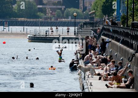 Manchester, Großbritannien, 19.. Juli 2022. Die Öffentlichkeit wird am Salford Quays in Manchester im Wasser gesehen, als am Sonntag um Mitternacht die erste rote Warnung Großbritanniens vor außergewöhnlicher Hitze in Kraft trat. Die Temperaturen in einigen Teilen des Landes sind auf über 40 Grad Celsius angestiegen und brechen damit die Hitzeberichte des Landes, Manchester, Großbritannien. Kredit: Jon Super/Alamy Live Nachrichten. Stockfoto