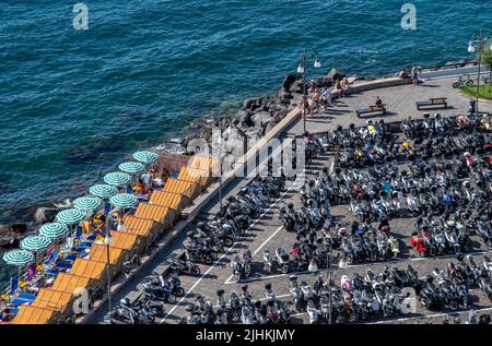 Blick auf Motrobikes und Motorroller, die in der Küstenstadt von Sorrent im Südwesten Italiens geparkt sind, mit Blick auf die Bucht von Neapel auf der Halbinsel Sorrentine. Italien. Stockfoto