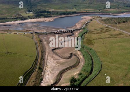 Manchester, Großbritannien. 19.. Juli 2022. Luftaufnahme vom 19. Juli 2022 zeigt das teilweise leere Woodhead Reservoir in der Nähe von Manchester, Großbritannien. Ein kürzlich von der Gemeinsamen Forschungsstelle der Europäischen Kommission erhaltener Bericht zeigt, dass fast die Hälfte des Territoriums der Europäischen Union (EU) und Großbritanniens im Juli von Dürre bedroht ist. Dürrebedingungen und Wasserknappheit beeinträchtigen die Energieproduktion und verringern den Ernteertrag. Quelle: Jon Super/Xinhua/Alamy Live News Stockfoto