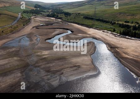 Manchester, Großbritannien. 19.. Juli 2022. Luftaufnahme vom 19. Juli 2022 zeigt das teilweise leere Woodhead Reservoir in der Nähe von Manchester, Großbritannien. Ein kürzlich von der Gemeinsamen Forschungsstelle der Europäischen Kommission erhaltener Bericht zeigt, dass fast die Hälfte des Territoriums der Europäischen Union (EU) und Großbritanniens im Juli von Dürre bedroht ist. Dürrebedingungen und Wasserknappheit beeinträchtigen die Energieproduktion und verringern den Ernteertrag. Quelle: Jon Super/Xinhua/Alamy Live News Stockfoto